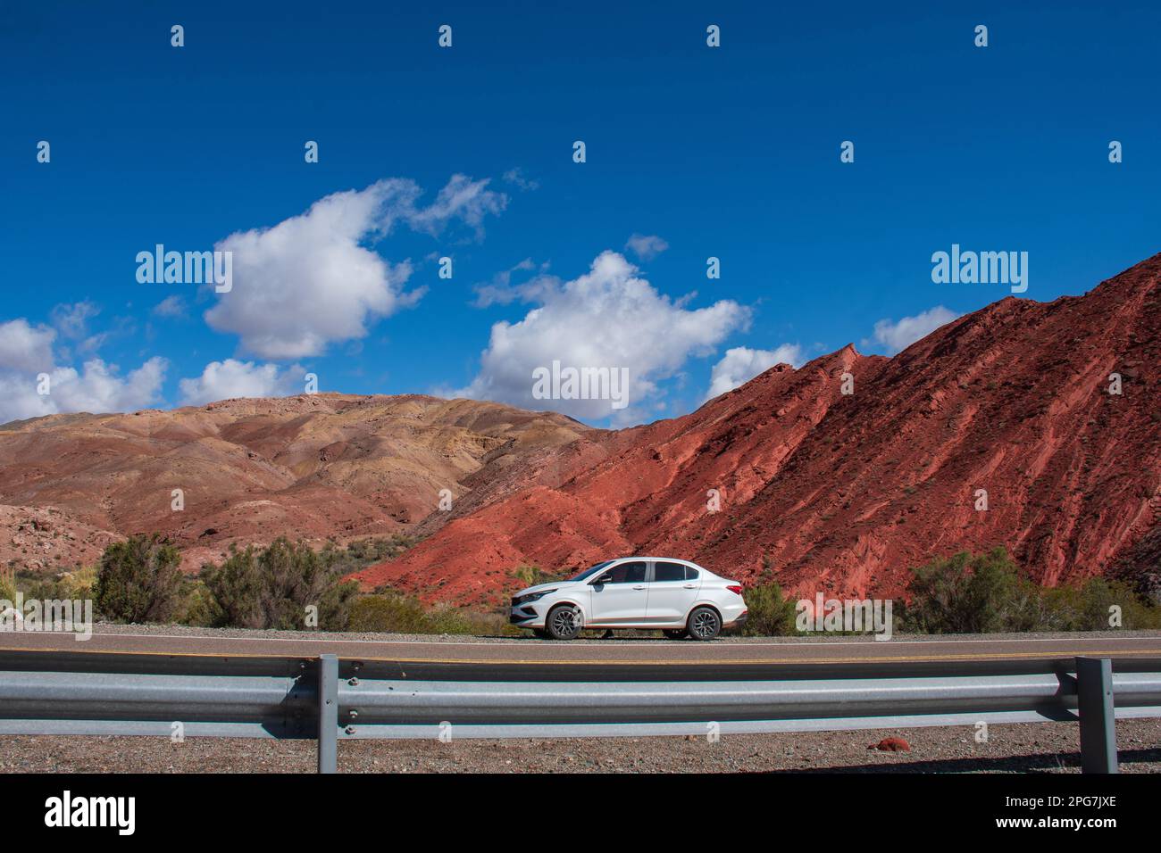 A white car parked against the backdrop of a majestic mountain range, Fiambala , Catamarca, Argentina Stock Photo