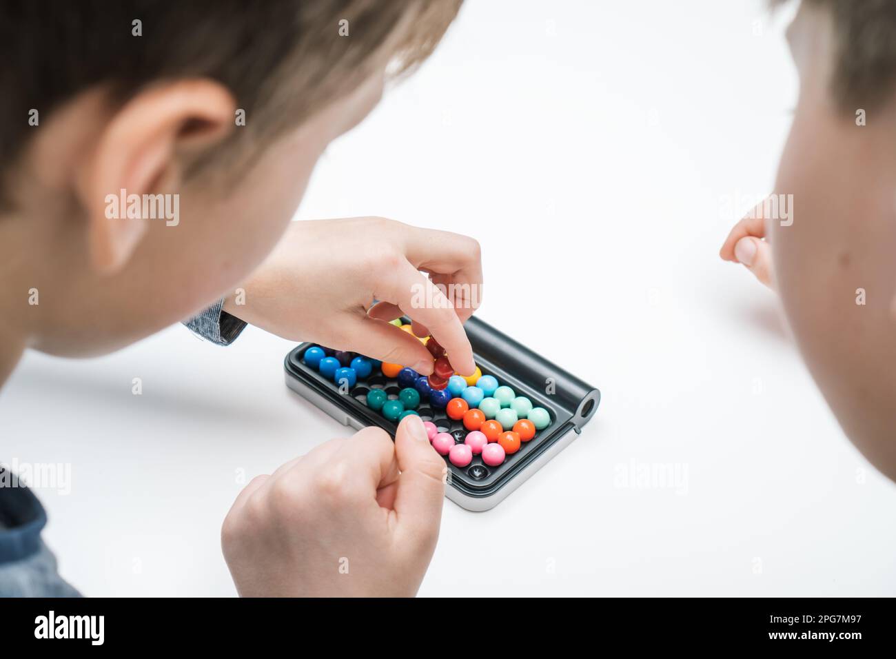 Close up rearview of boys playing educational, strategy board game with
