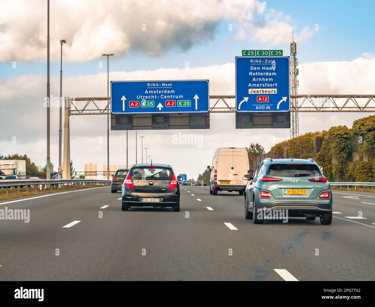 Cars and route information on overhead gantry, motorway A2 at exit to A12, traffic junction Oudenrijn, Utrecht, Netherlands Stock Photo