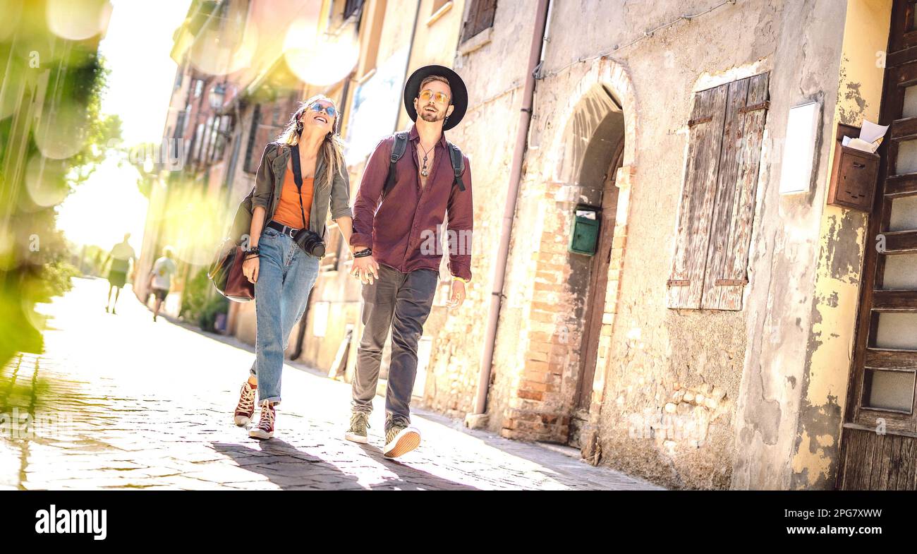 Happy couple in love having fun walking at old city center - Wanderlust life style and travel concept with young trendy tourists on sightseeing experi Stock Photo