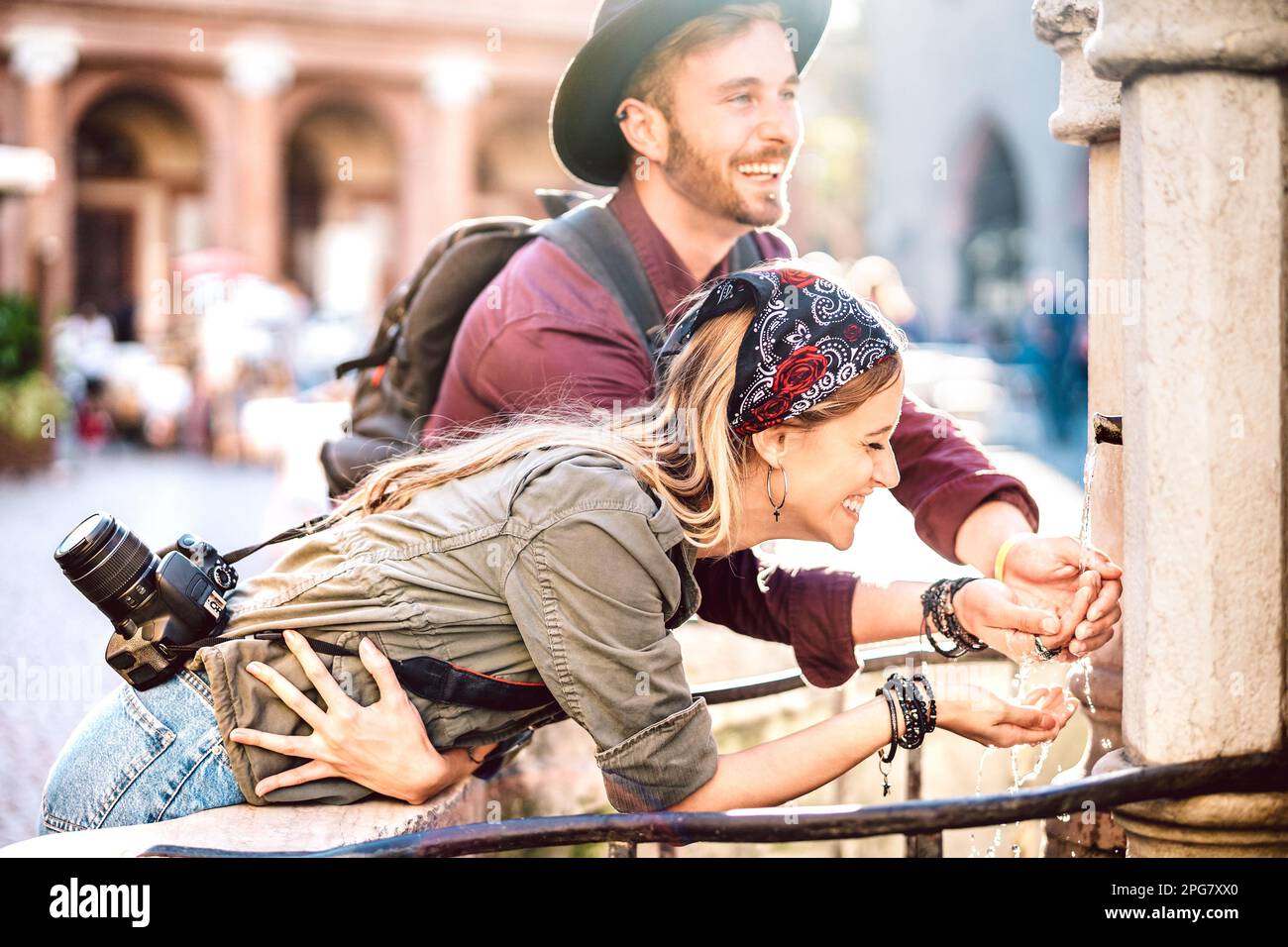 Young hipster couple in love having genuine fun wandering at city center - Wanderlust life style and travel concept with guy and girl together at old Stock Photo