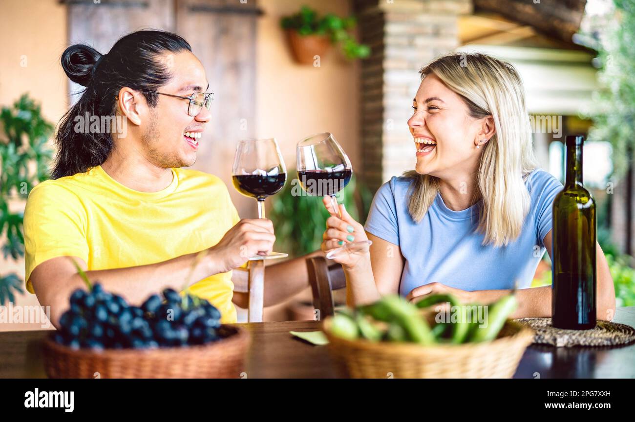 Happy couple in love toasting red wine at countryside farm house restaurant - Food and beverage life style concept with boyfriend and girlfriend Stock Photo