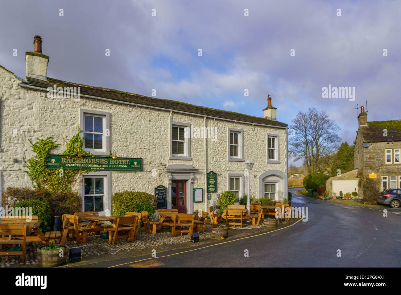 Racehorses Hotel in Kettlewell, Skipton, Upper Nidderdale, North Yorkshire, UK, with wooden tables and chairs lining the front. Stock Photo