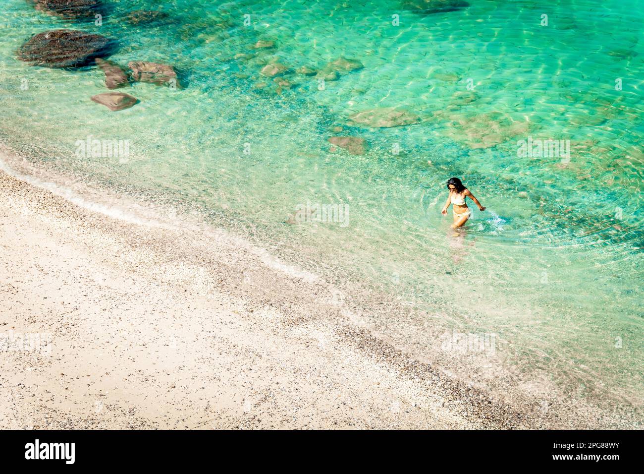 Aerial view isolated tourist woman in bikini walk on white sand beach
