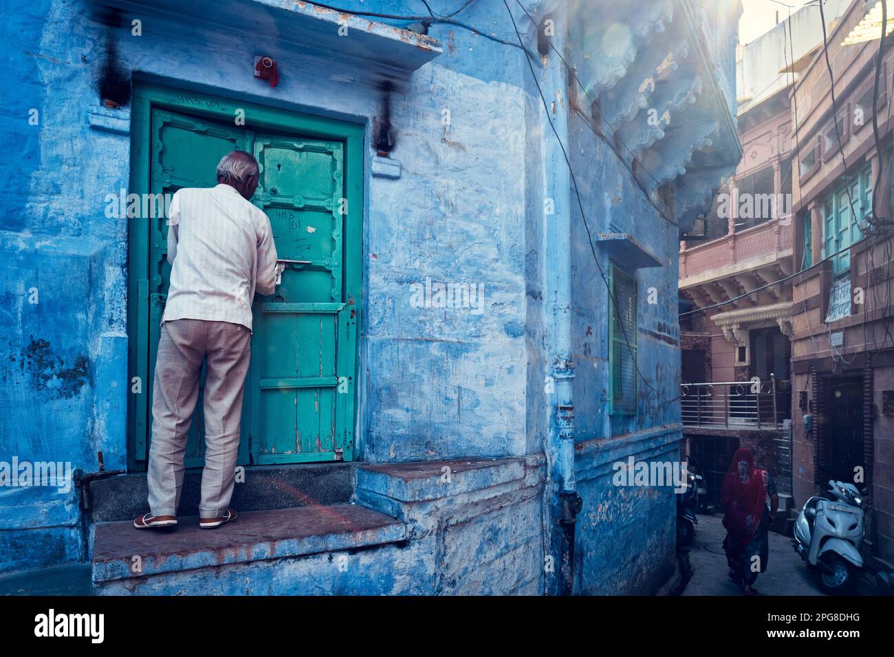 Indian man and his blue house in streets, Jodhpur, Rajasthan, India Stock Photo