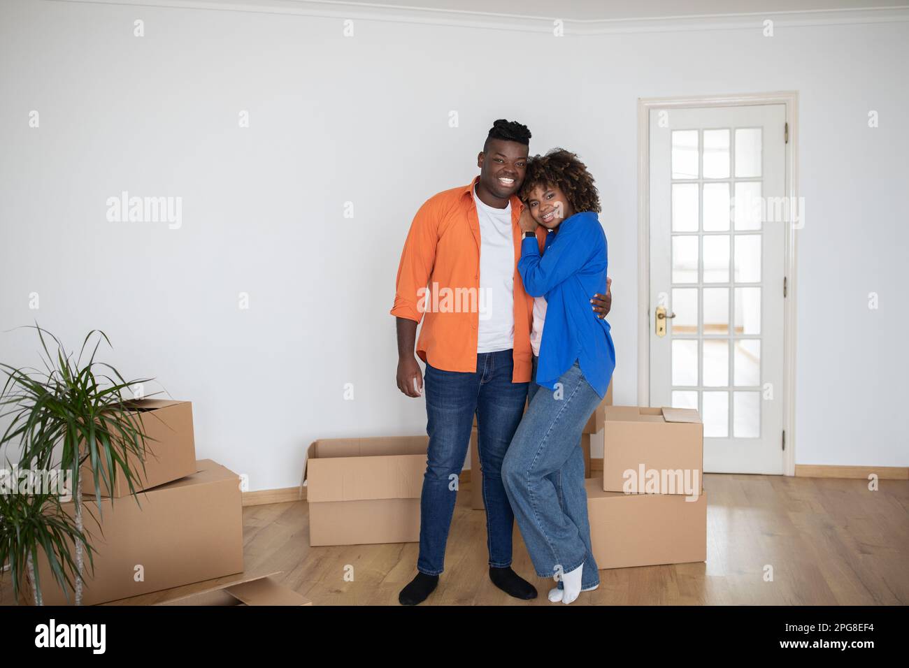 Happy Black Couple Posing In Their New Home On Moving Day Stock Photo ...