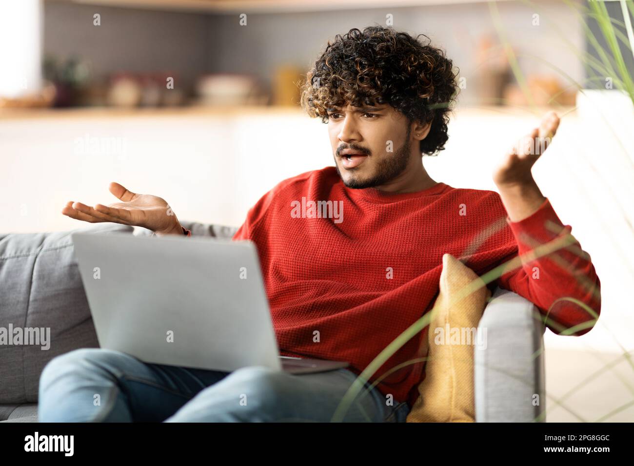 Stressed Young Indian Man Suffering Problems While Using Laptop At Home Stock Photo