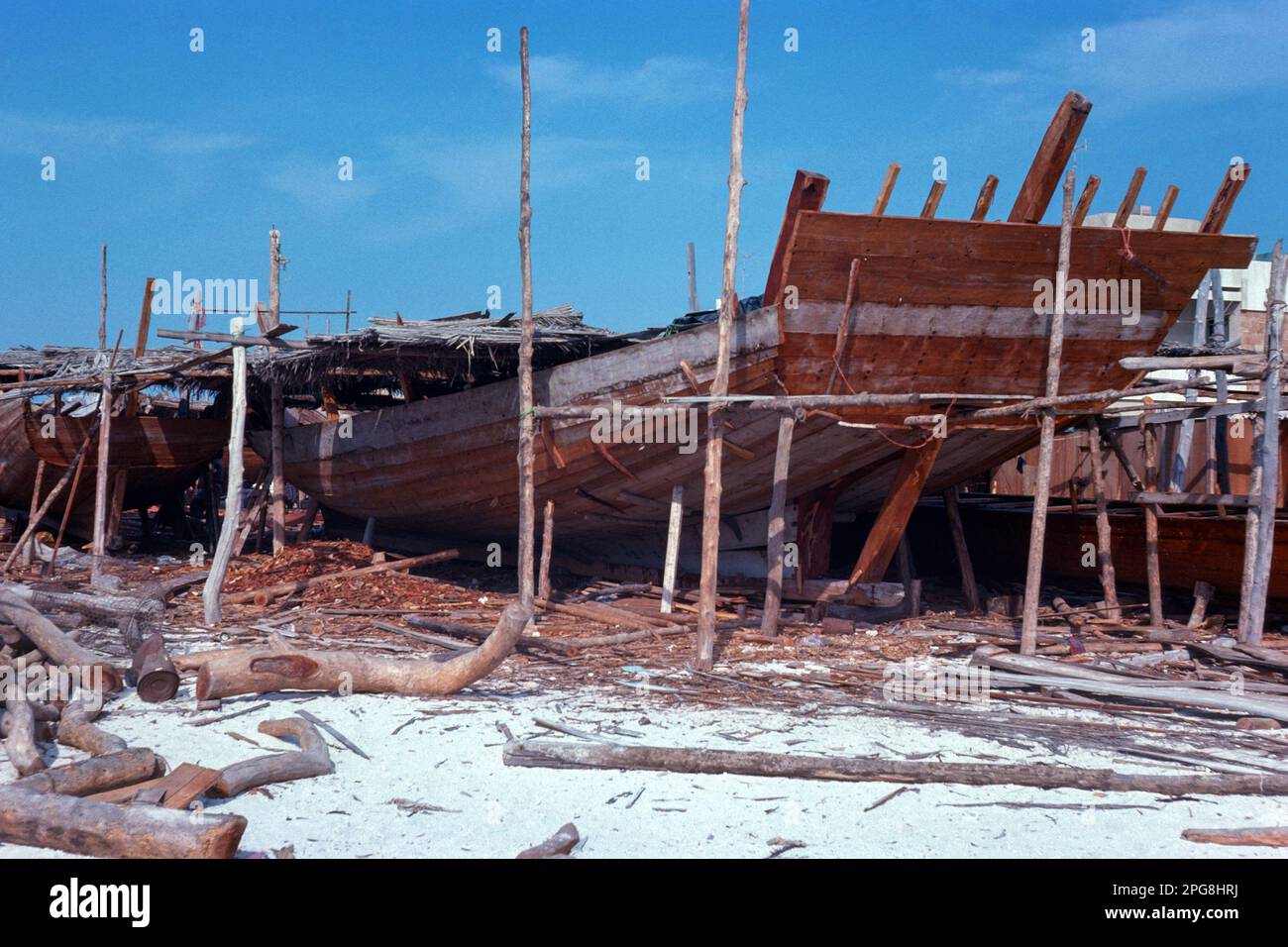 Abu Dhabi UAE 1976 – Dhow building yard at Al Bateen harbour (this area has now been redeveloped) in Abu Dhabi, United Arab Emirates Stock Photo