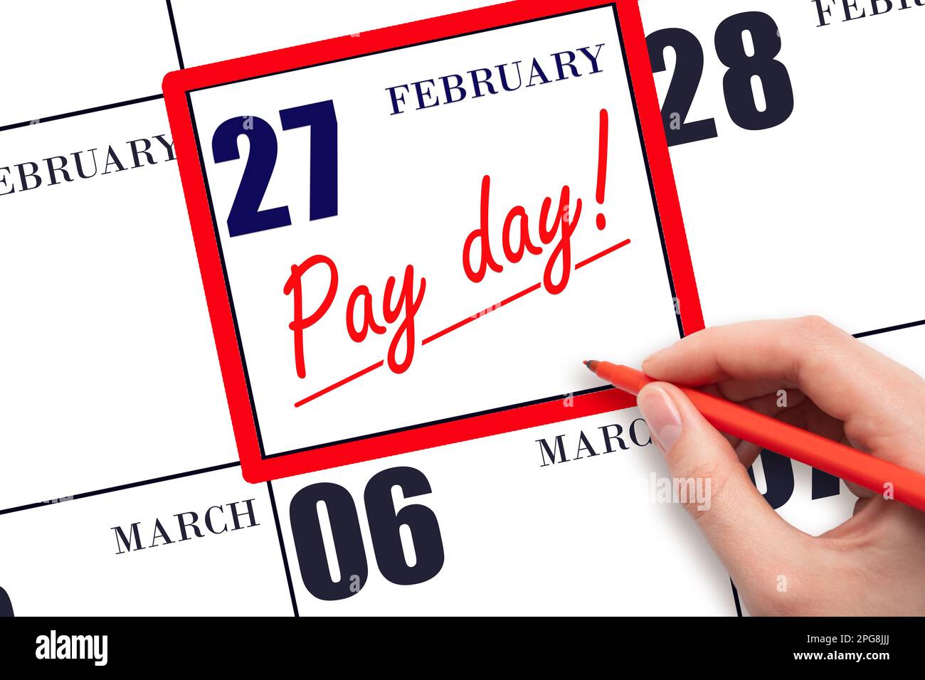 27th day of February. Hand writing text PAY DATE on calendar date February 27 and underline it. Payment due date. Reminder concept of payment. Winter Stock Photo