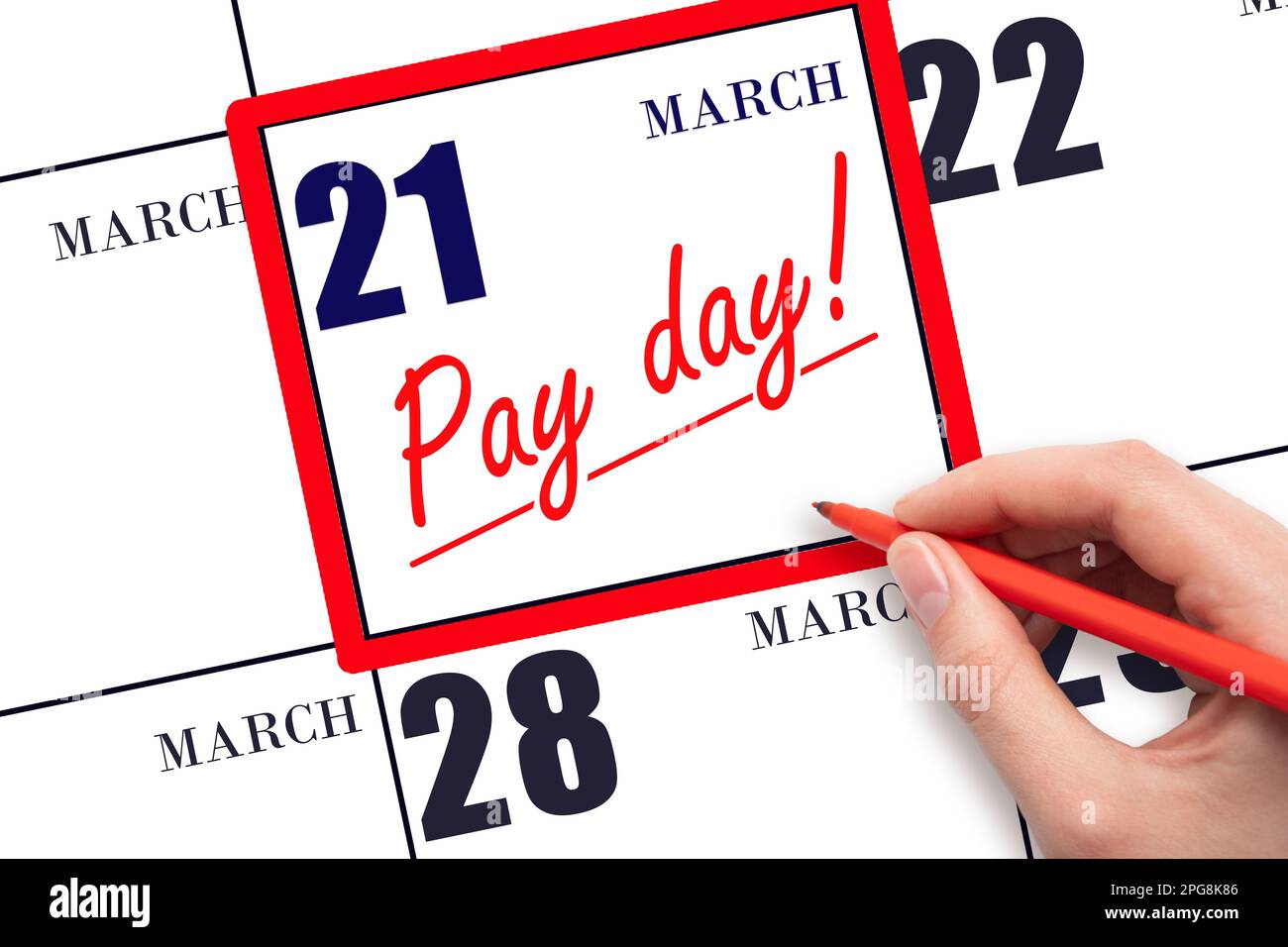 21st day of March. Hand writing text PAY DATE on calendar date March 21 and underline it. Payment due date. Reminder concept of payment. Spring month, Stock Photo
