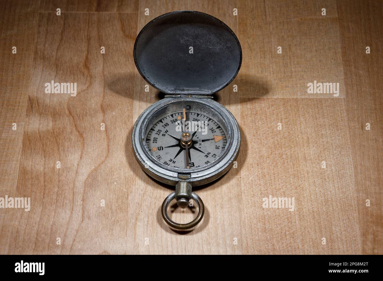 Open old vintage compass on wooden table Stock Photo