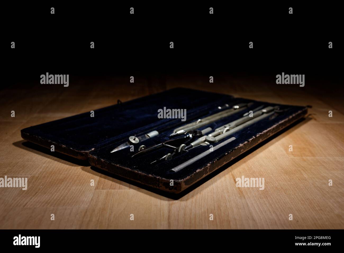 set of divider, compass inside a box for geometric construction lying on wooden table Stock Photo
