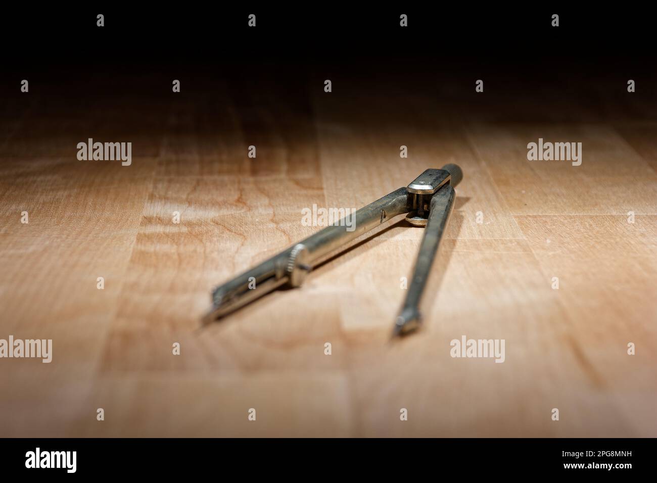 divider. compass for geometric construction lying on wooden table Stock Photo