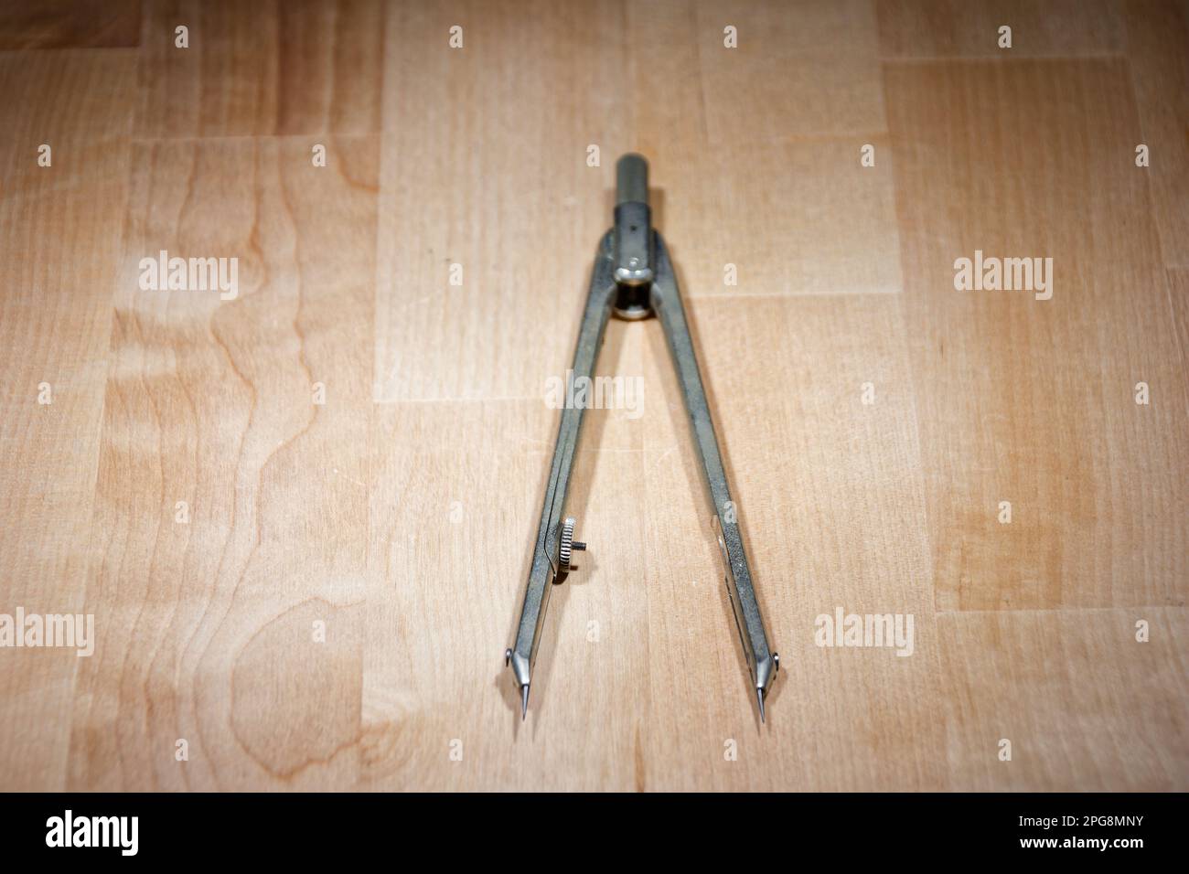 divider. compass for geometric construction lying on wooden table Stock Photo
