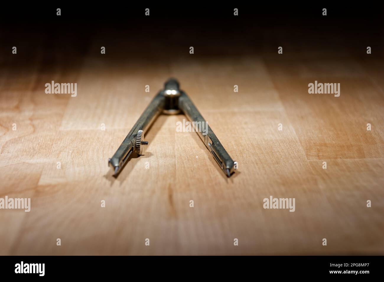 divider. compass for geometric construction lying on wooden table Stock Photo