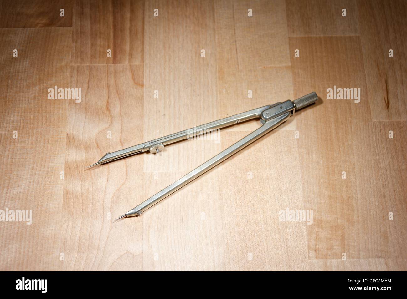 divider. compass for geometric construction lying on wooden table Stock Photo
