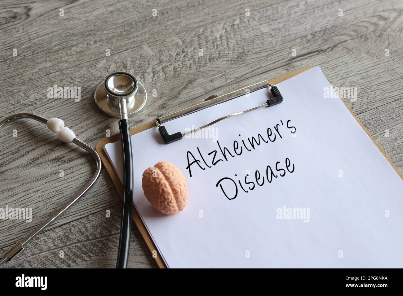 Stethoscope, human brain model and paper clipboard with text Alzheimer's Disease. Medical and healthcare concept Stock Photo