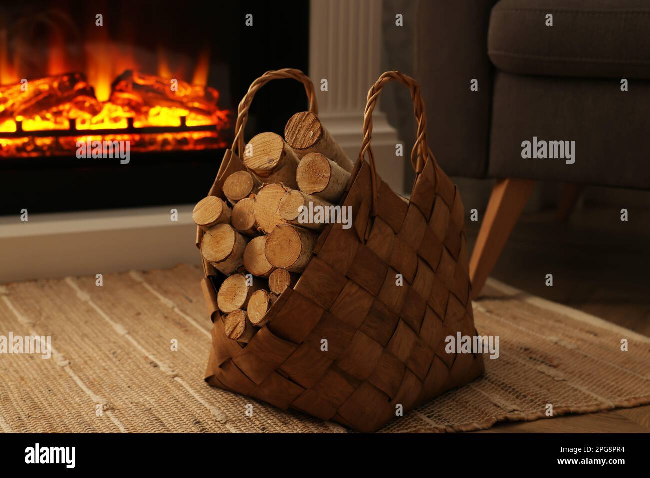 Wicker basket with wood near fireplace in room Stock Photo Alamy