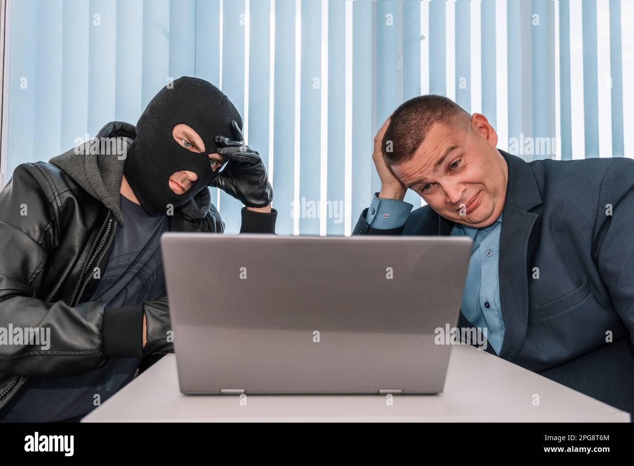 The extortionist thief demands money in the businessman's office. Theft of personal data. Bank robbery. the concept of extortion and robbery. Stock Photo
