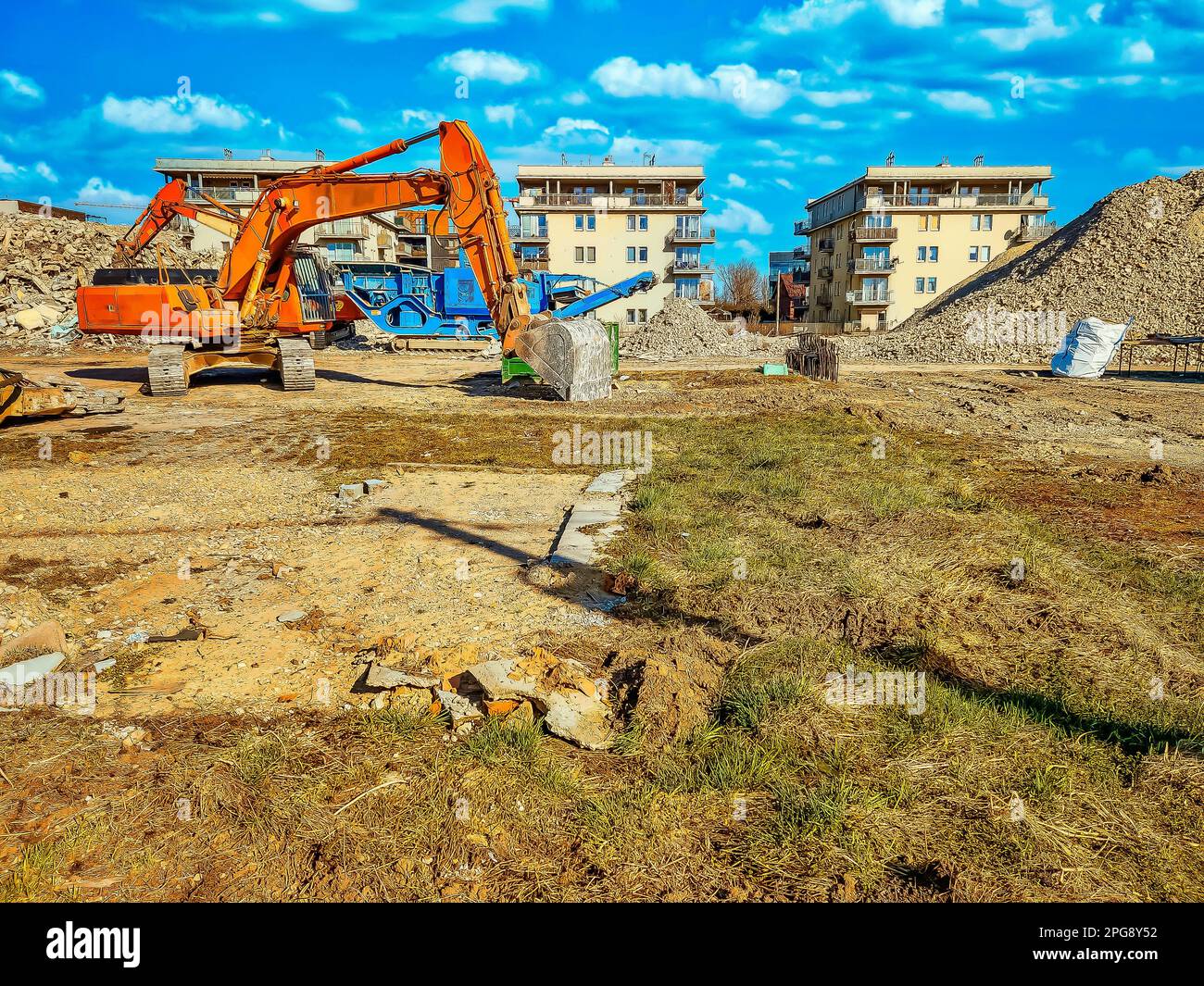 Orange excavator on the site of bilding, dismantling of building Stock Photo