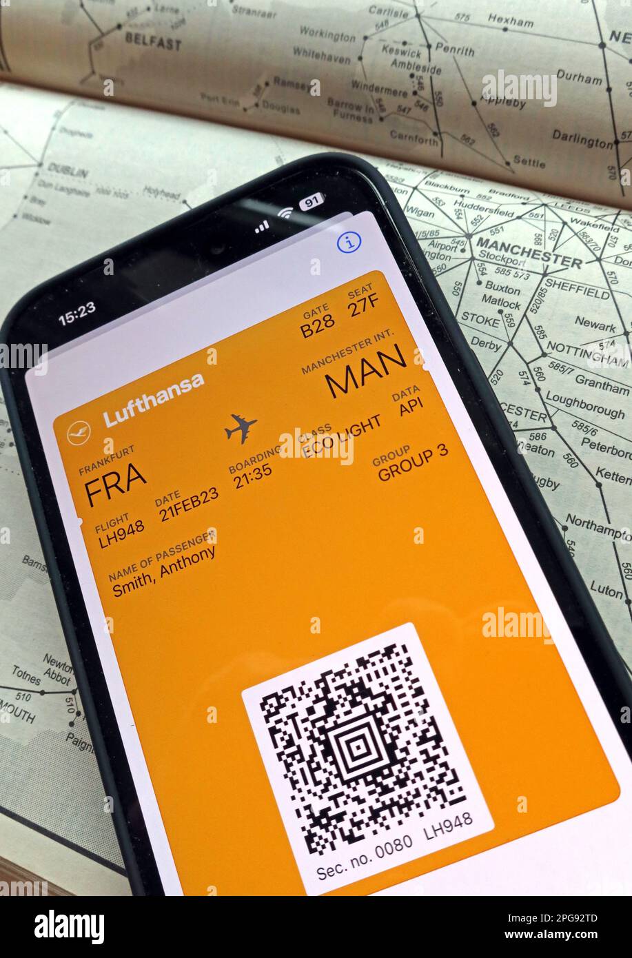 Airplane flight digital boarding pass FRA-MAN on mobile phone, with Lufthansa, and rail transport map of Manchester, North West England Stock Photo
