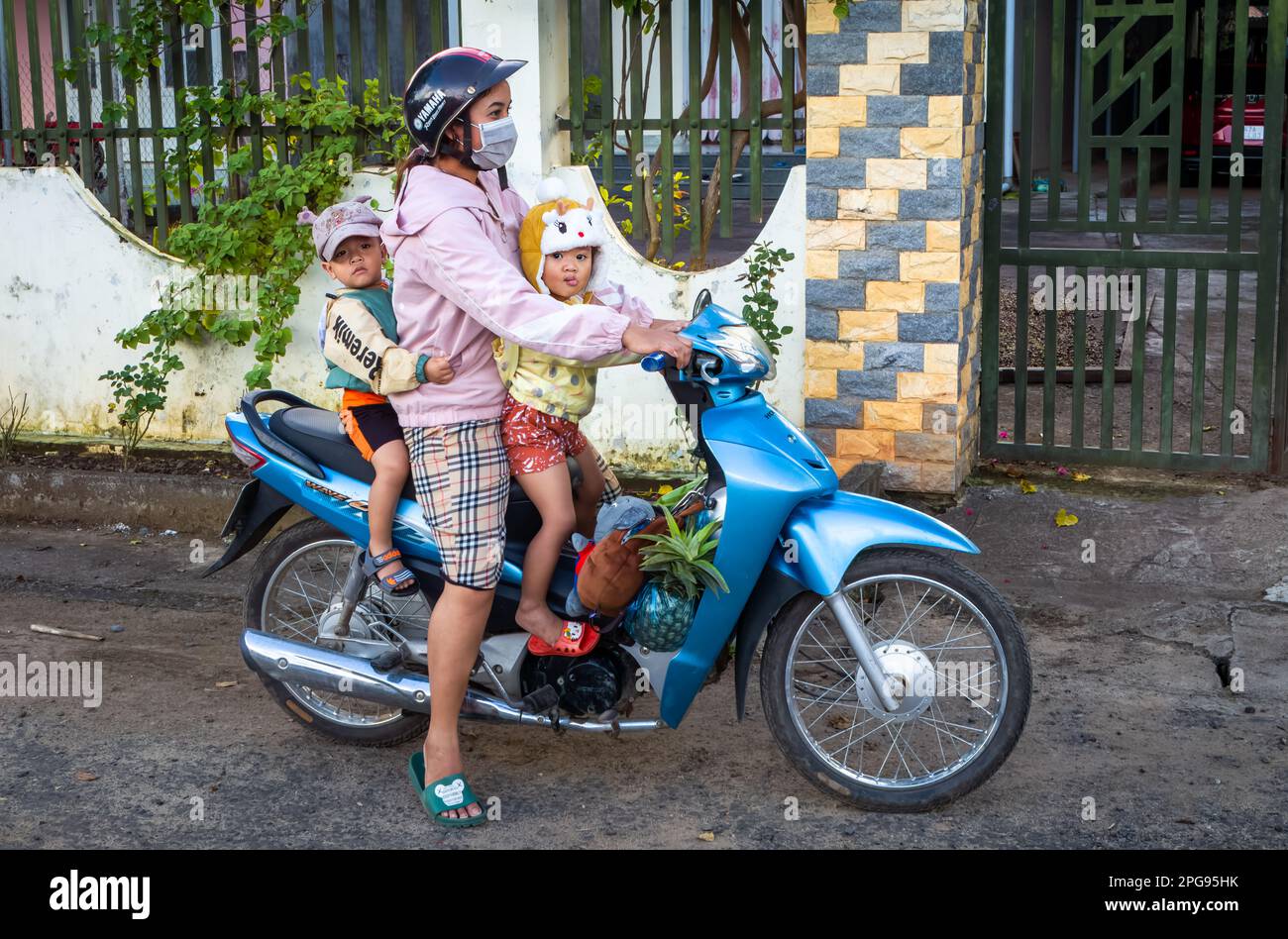 A mother carries her two young chiildren on a Honda Wave motorcycle scooter in Buon Jun, Lien Son, Vietnam. Stock Photo