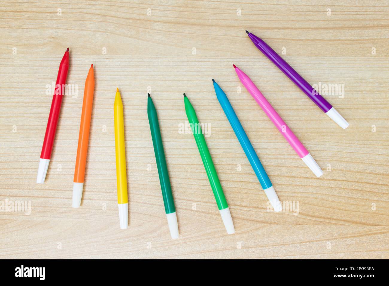 A set of neatly stacked colored markers on a wooden background. Stock Photo  by ©Vladimir75 361893676