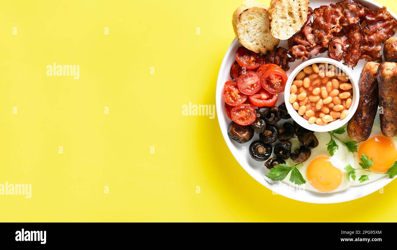 Close up view of full english breakfast with fried egg, bacon, sausage ...