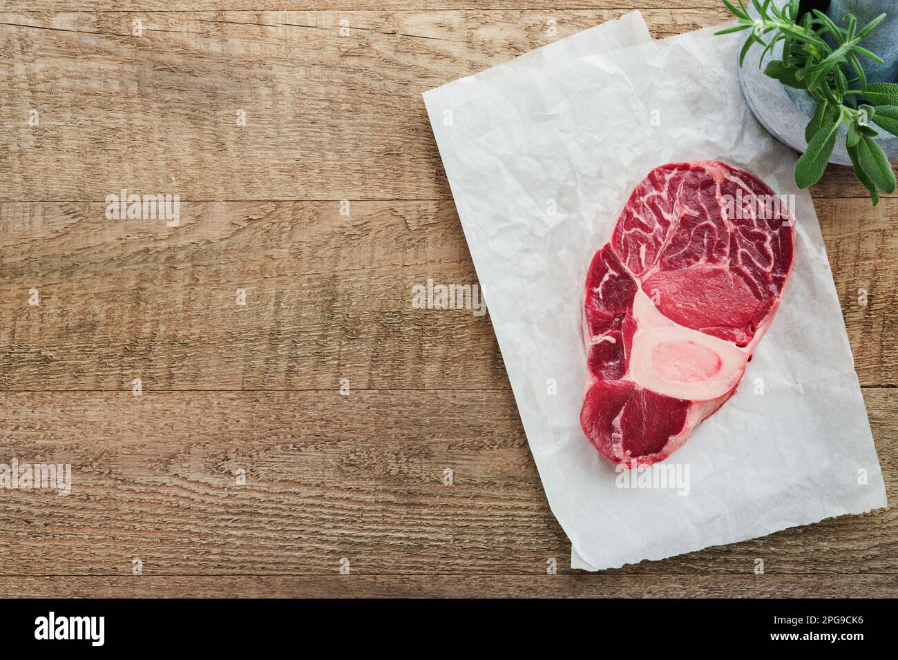 Osso Buco raw steak meat. Barbecue meat. Raw fresh cross cut veal shank and seasonings pepper, rosemary, thyme and salt on old wooden background. Beef Stock Photo
