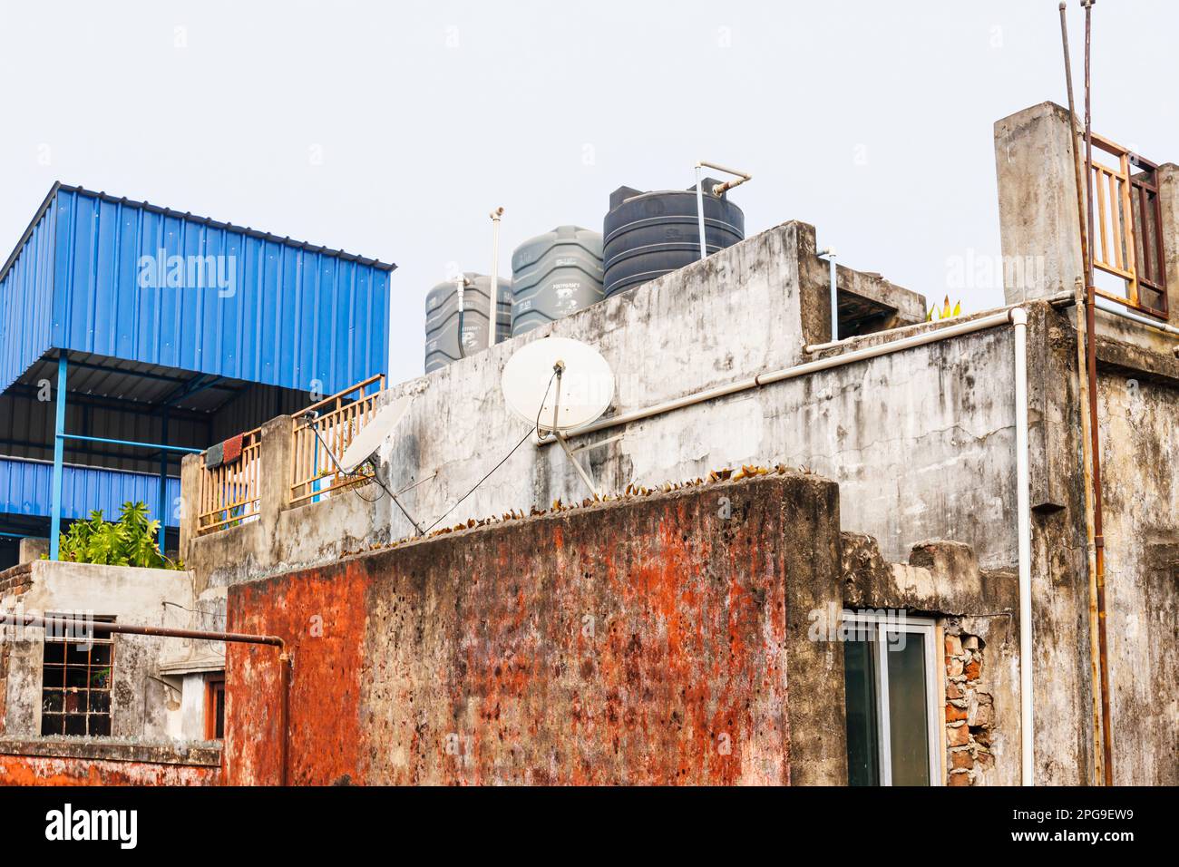 Rooftop view of a wall with broken glass top in local suburban buildings in Fariapukur, Shyam Bazar, Kolkata (Calcutta), capital of West Bengal, India Stock Photo
