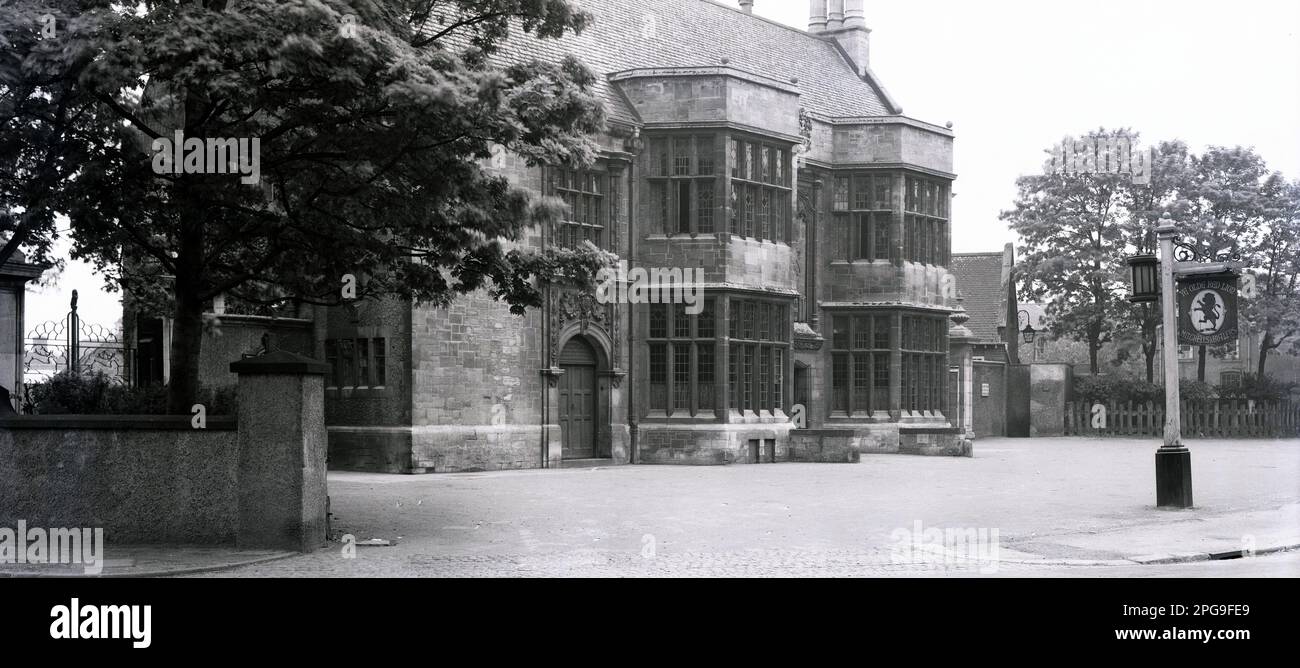 1950s, historical, exterior of The Red Lion public house, an elegant old buidling in Vicarage Rd, Kings Heath, Birmingham, England, UK. A hanging sign outside says; Ye Olde Red Lion. At this time it was a Mitchells & Butlers licensed premises. The pub was built in 1904 by the Priory Estate Co as an 'improved pub', to serve a new housing estate, the concept being to recreate 'Olde Englishe' taverns and move away from Victorian gin palaces. Architecturally, the building was influenced by the Arts & Crafts movement and was based on the Angel and Royal in Grantham in Lincolnshire. Stock Photo