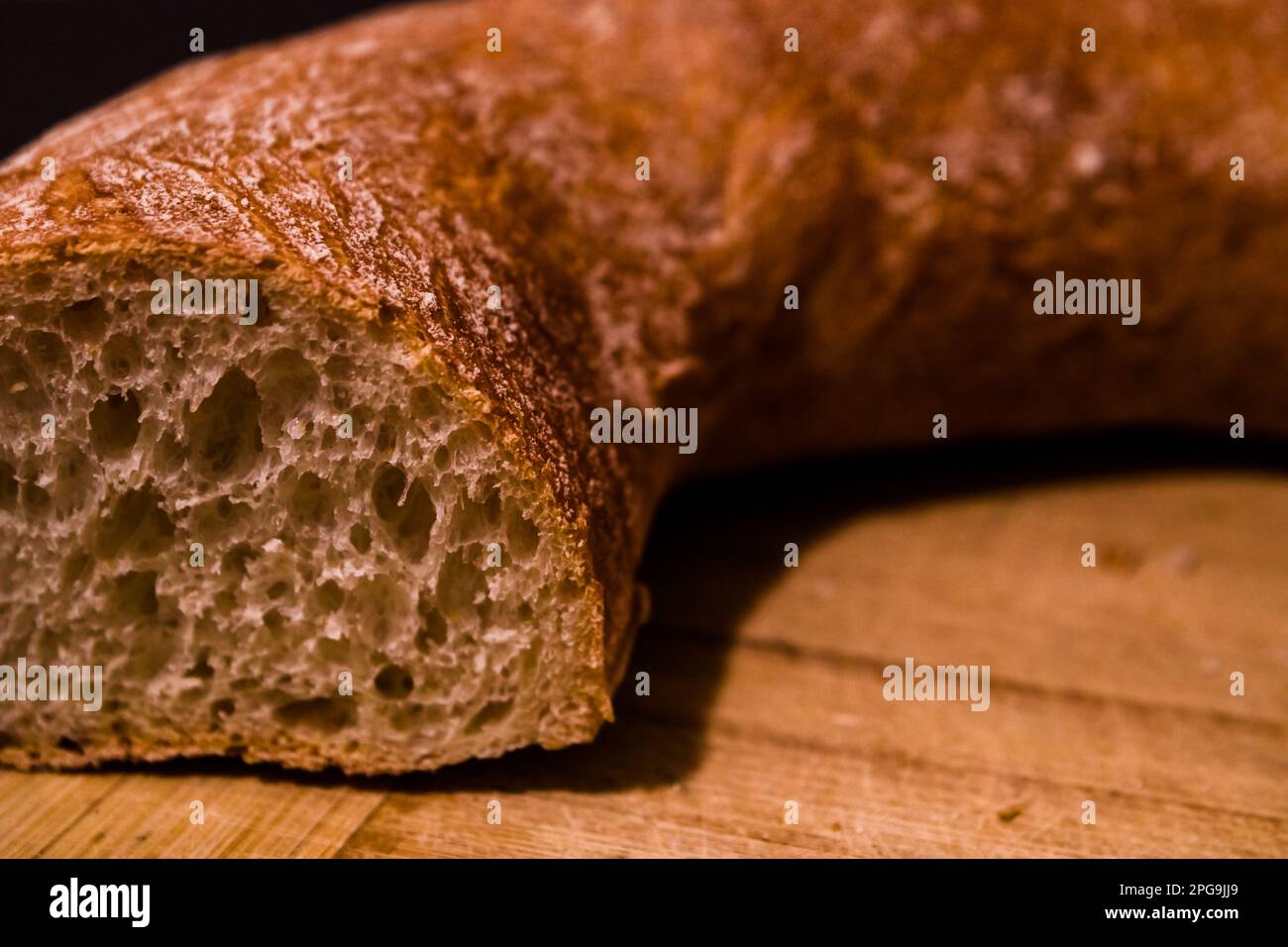 Fresh crispy sliced bread on black board and knife, on a black ...
