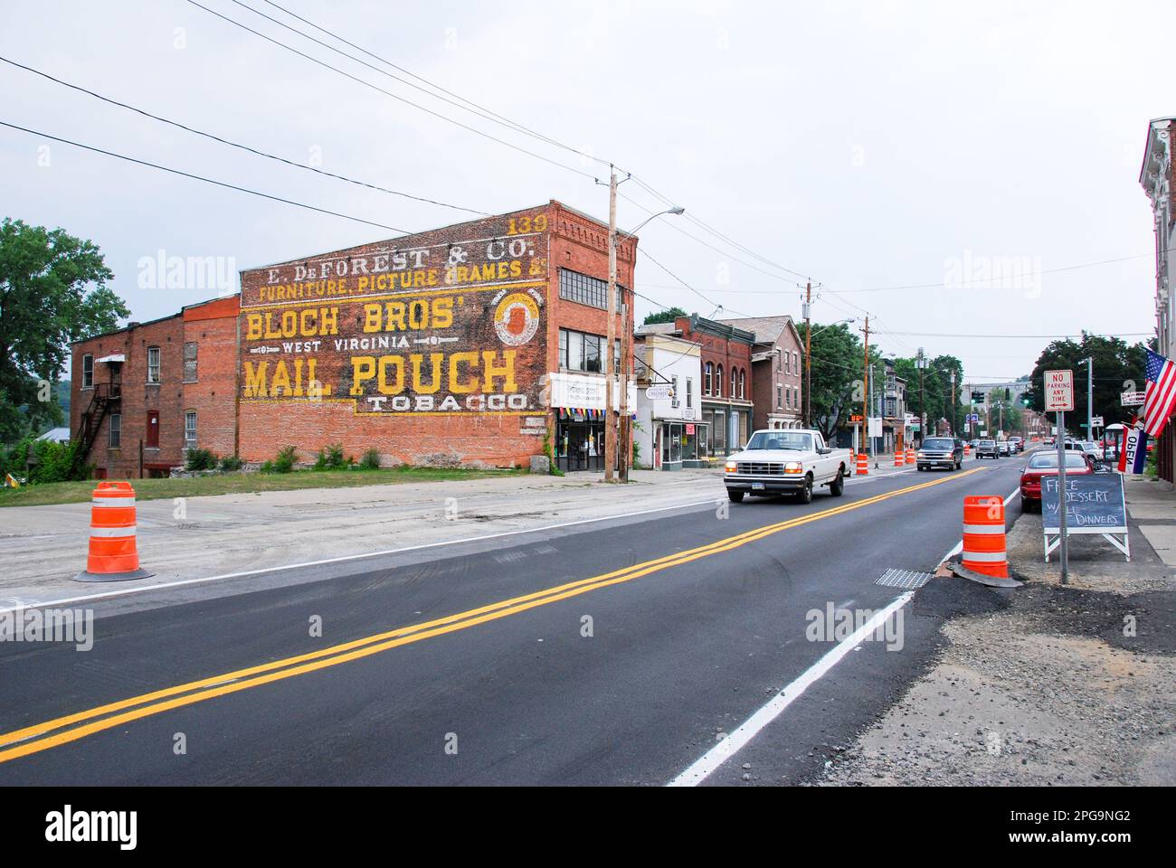 Whitehall, NY, USA: Three story brick building on Broadway with three story hand-painted 'Mail Pouch Tobacco' sign in distinctive yellow. Other painte Stock Photo