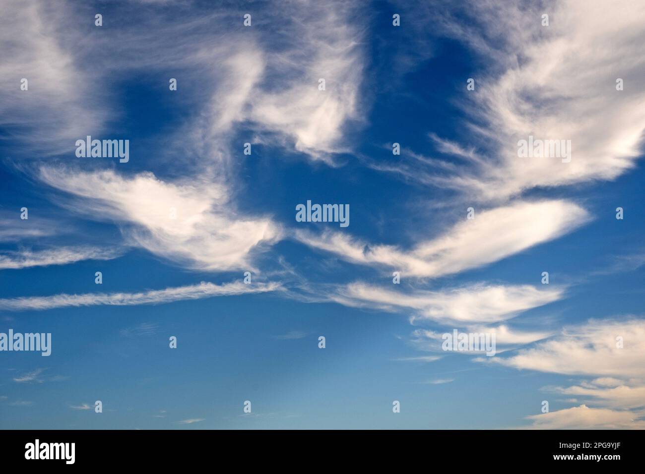 Clouds float by in a blue sky. Stock Photo
