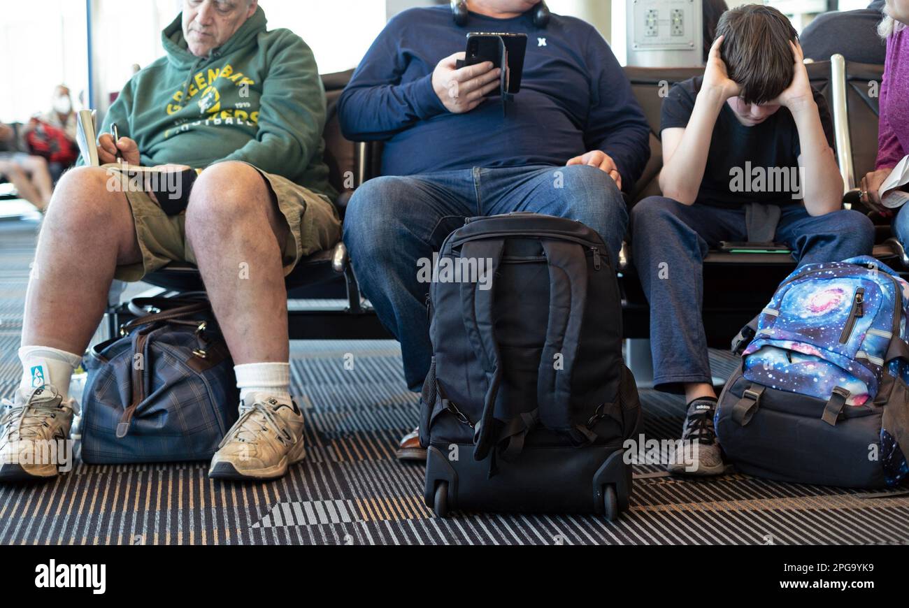 People wait for their flight departure at an airport. Stock Photo