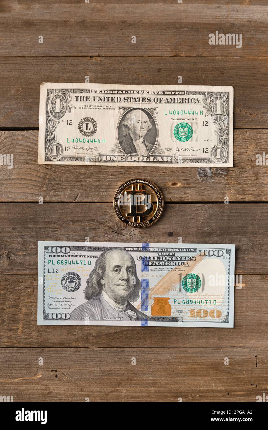 Bitcoin and banknotes of 1 and 100 dollars on a wooden background, top  view. The concept of investment, savings, exchanging cryptocurrency for  dollars Stock Photo - Alamy