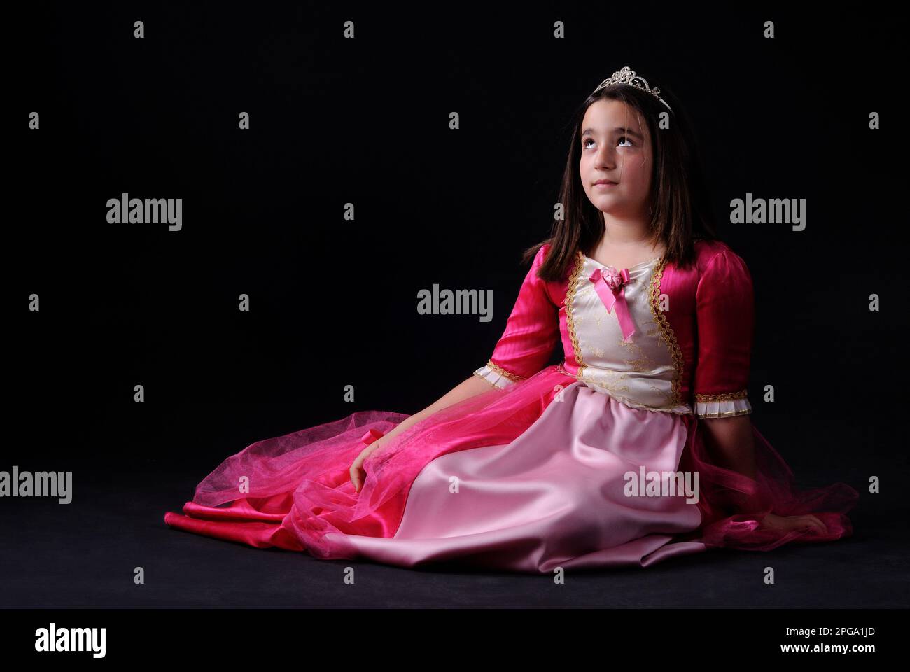beautiful little girl in a pink dress on a black background Stock Photo ...