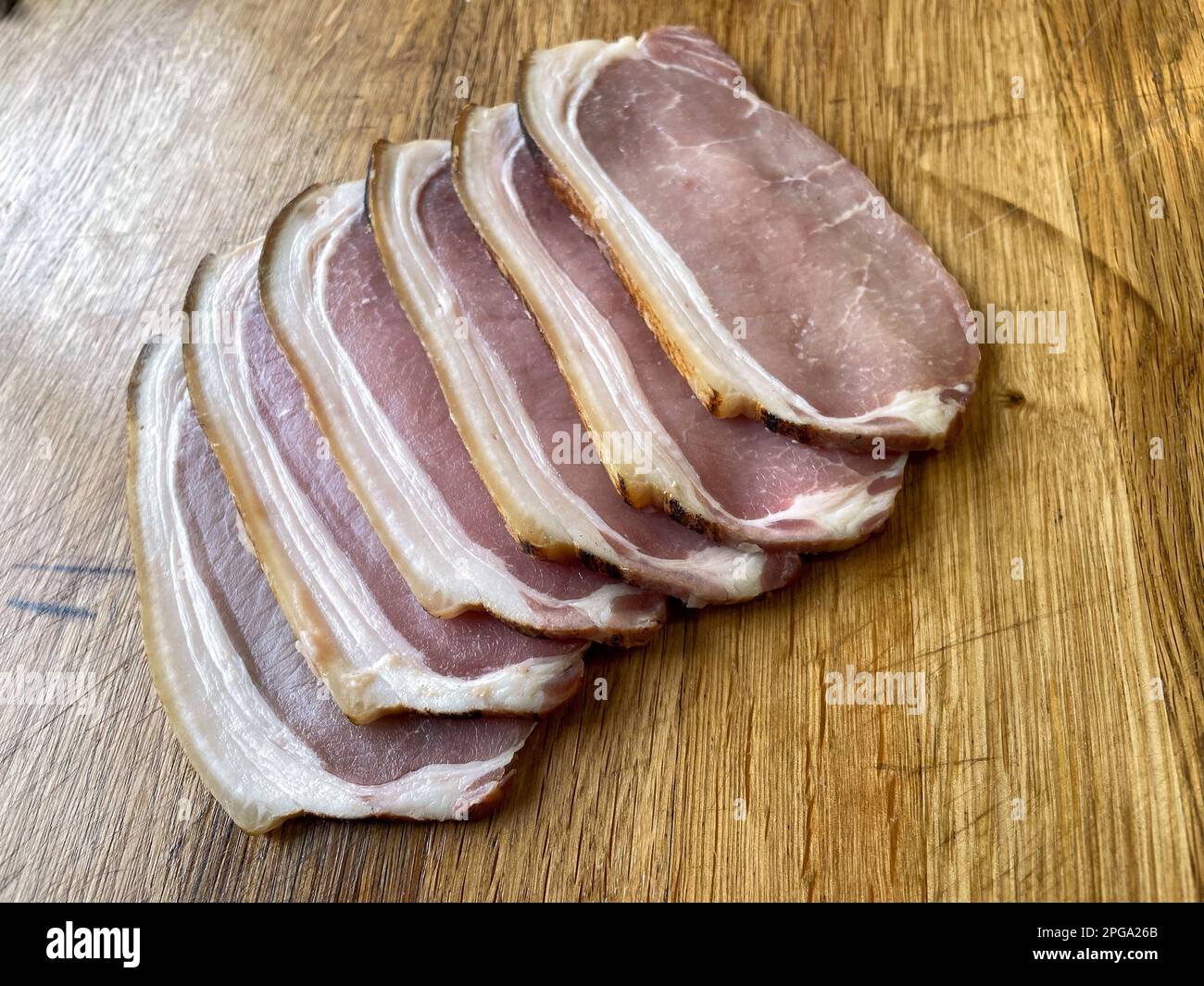 https://c8.alamy.com/comp/2PGA26B/dry-cure-sliced-back-bacon-on-a-wooden-table-six-rashes-2PGA26B.jpg