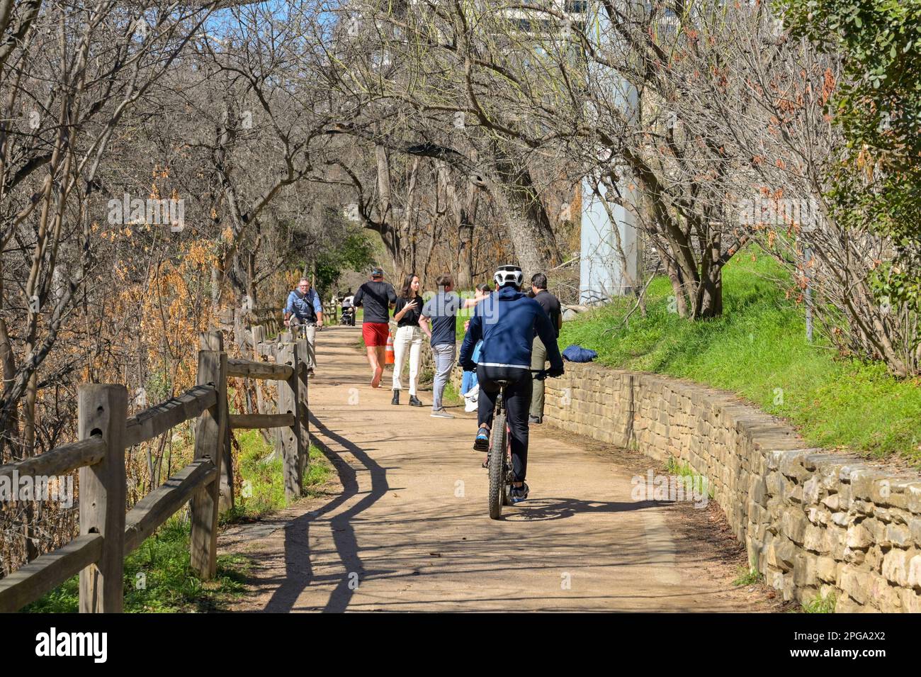 Austin, Texas, USA - February 2023: People walking and cycling on the path alongside the river near the city centre Stock Photo