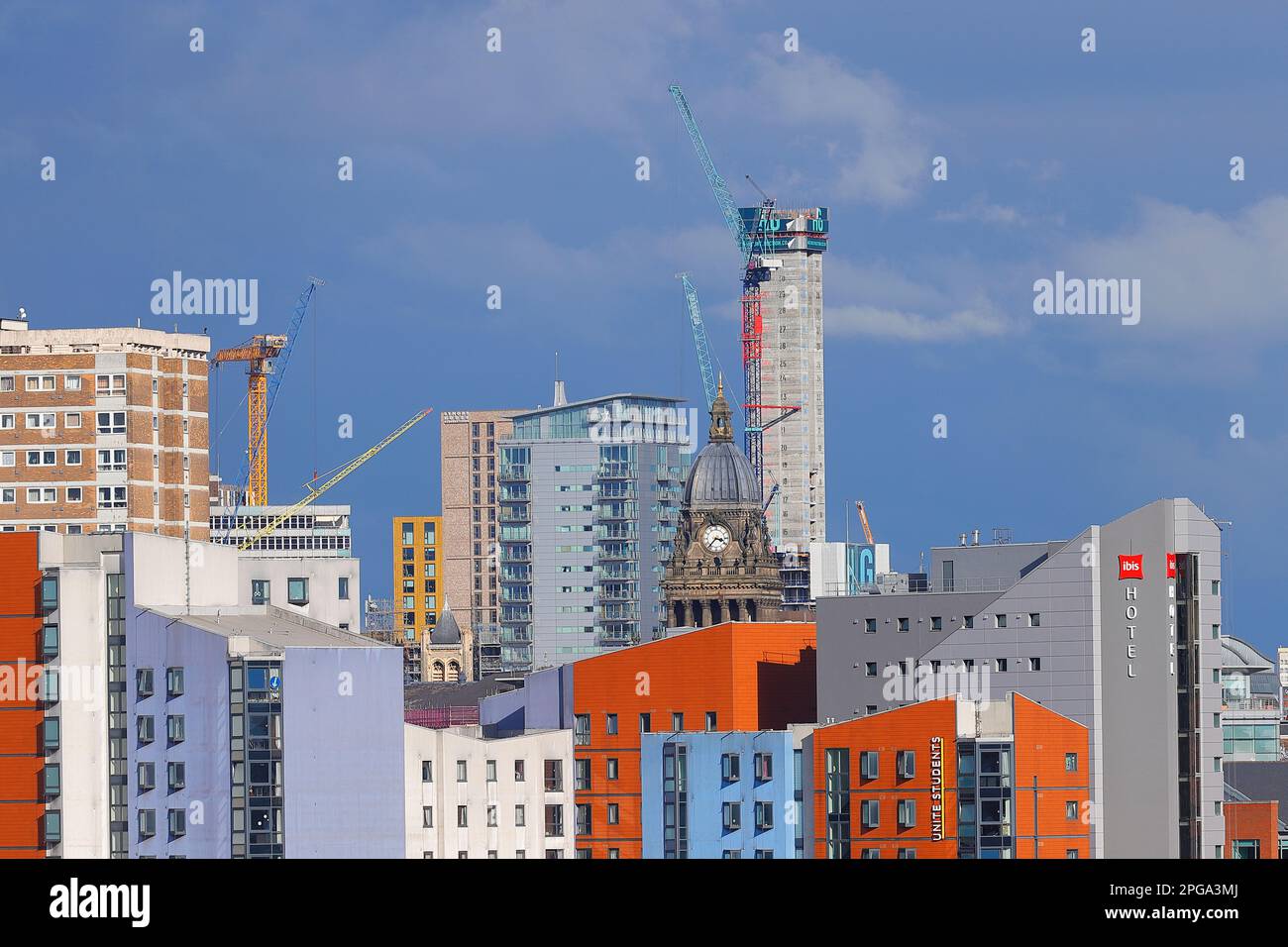 Leeds Town Hall clock tower pictured next to a 31 storey building under construction in Leeds city centre Stock Photo