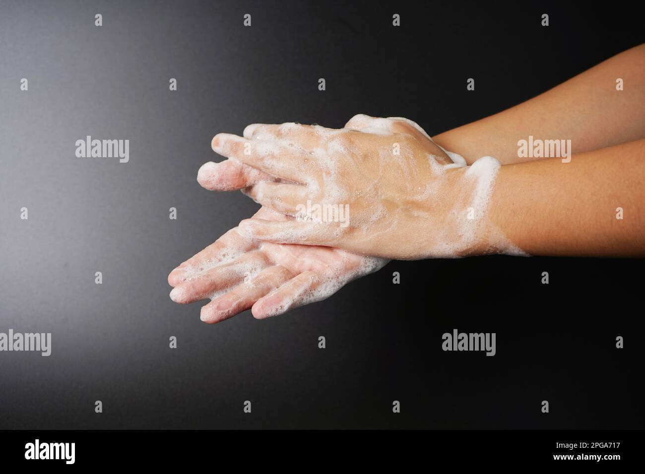 Washing hand with soap on dark background Stock Photo