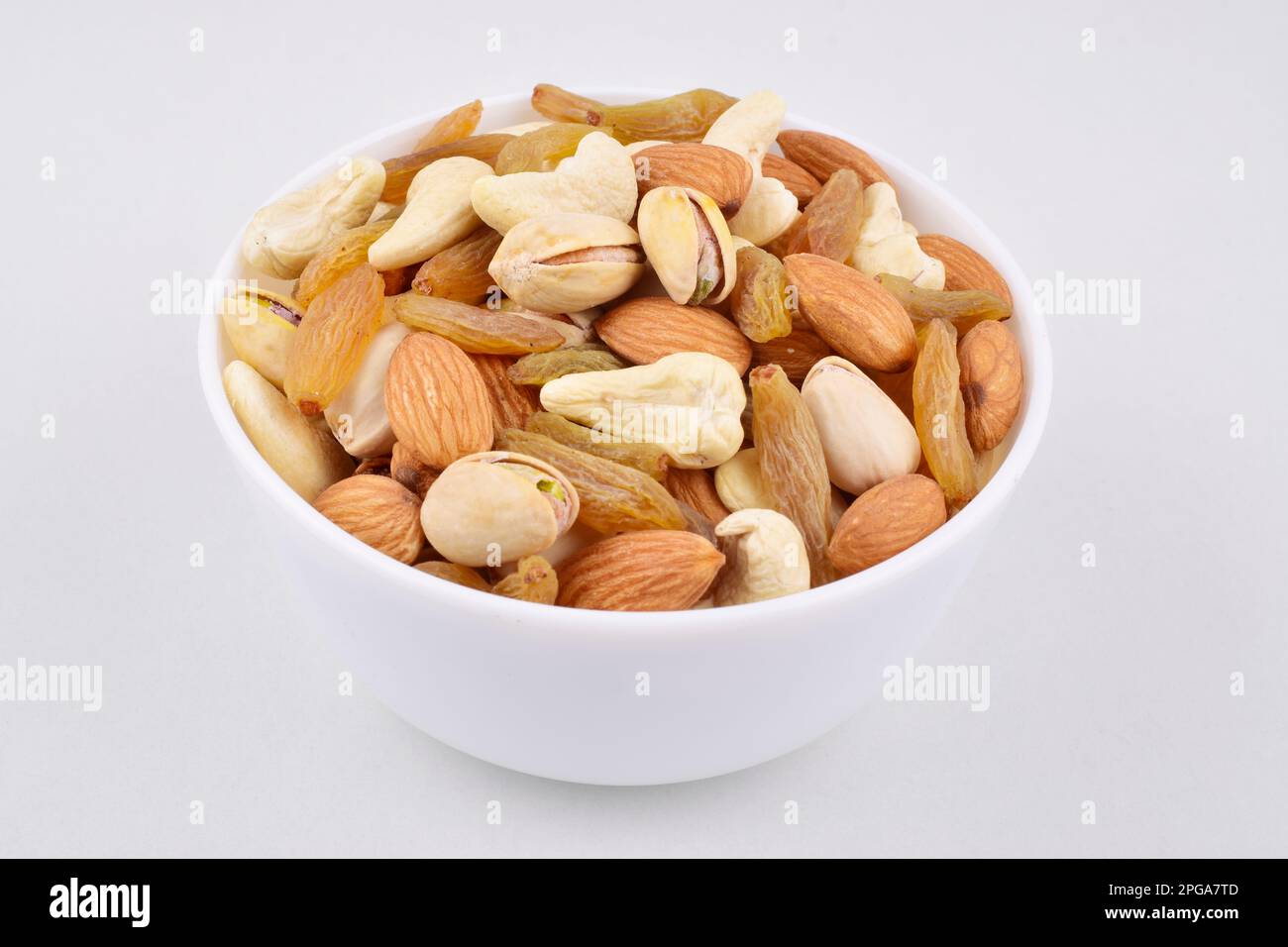 Mix nuts in bowl on white background, almond,pistachio, cashew and raisins healthy food Stock Photo