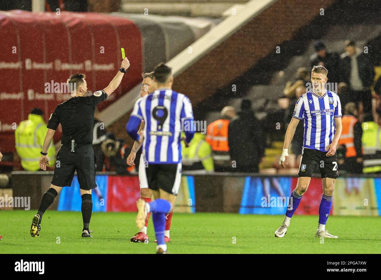 Referee Ross Joyce  gives a yellow card to Michael Smith #24 of Sheffield Wednesday during the Sky Bet League 1 match Barnsley vs Sheffield Wednesday at Oakwell, Barnsley, United Kingdom, 21st March 2023  (Photo by Mark Cosgrove/News Images) Stock Photo