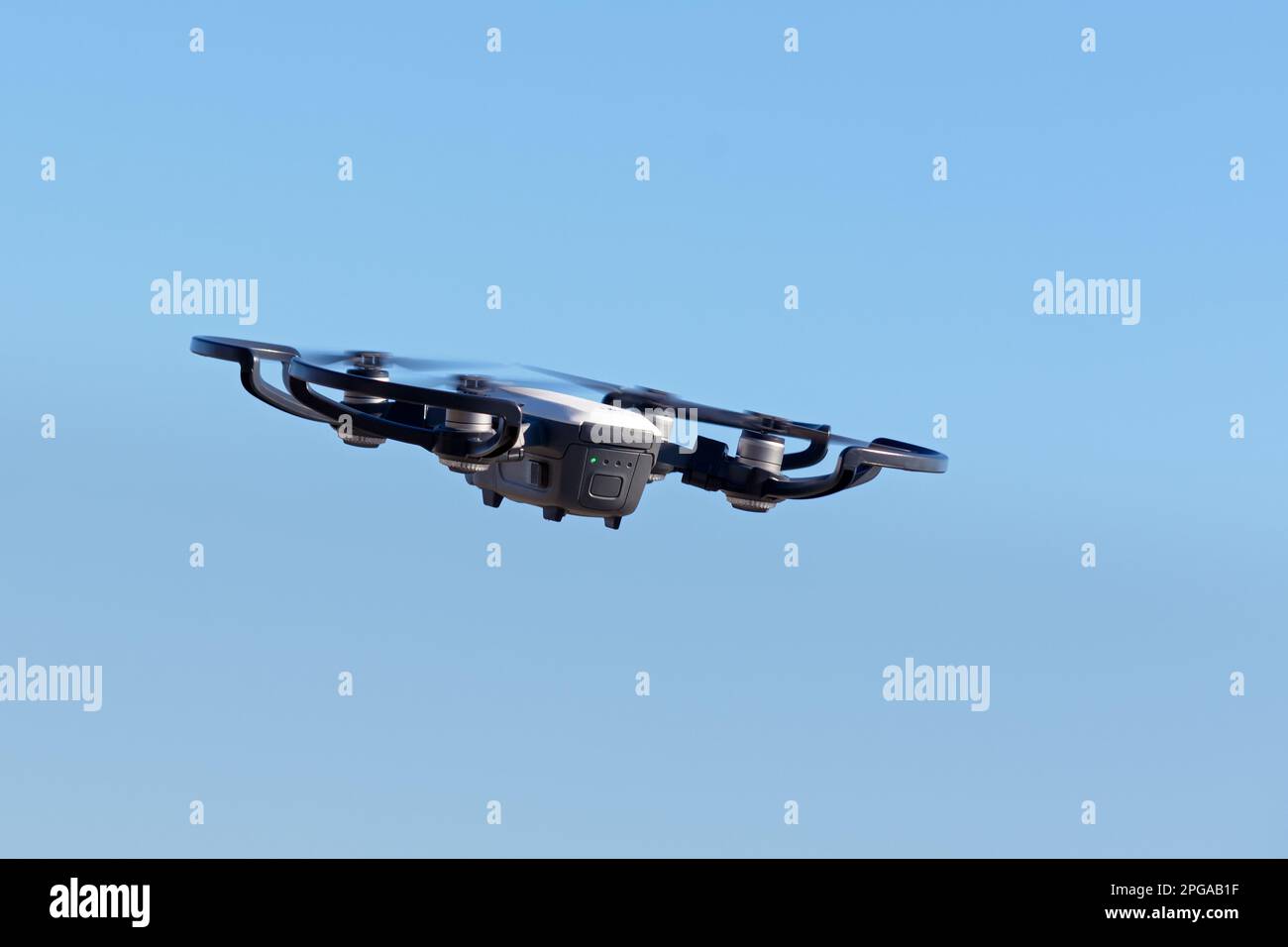 remote aerial quadcopter drone, with hight resolution camera, flying in the blue sky, which