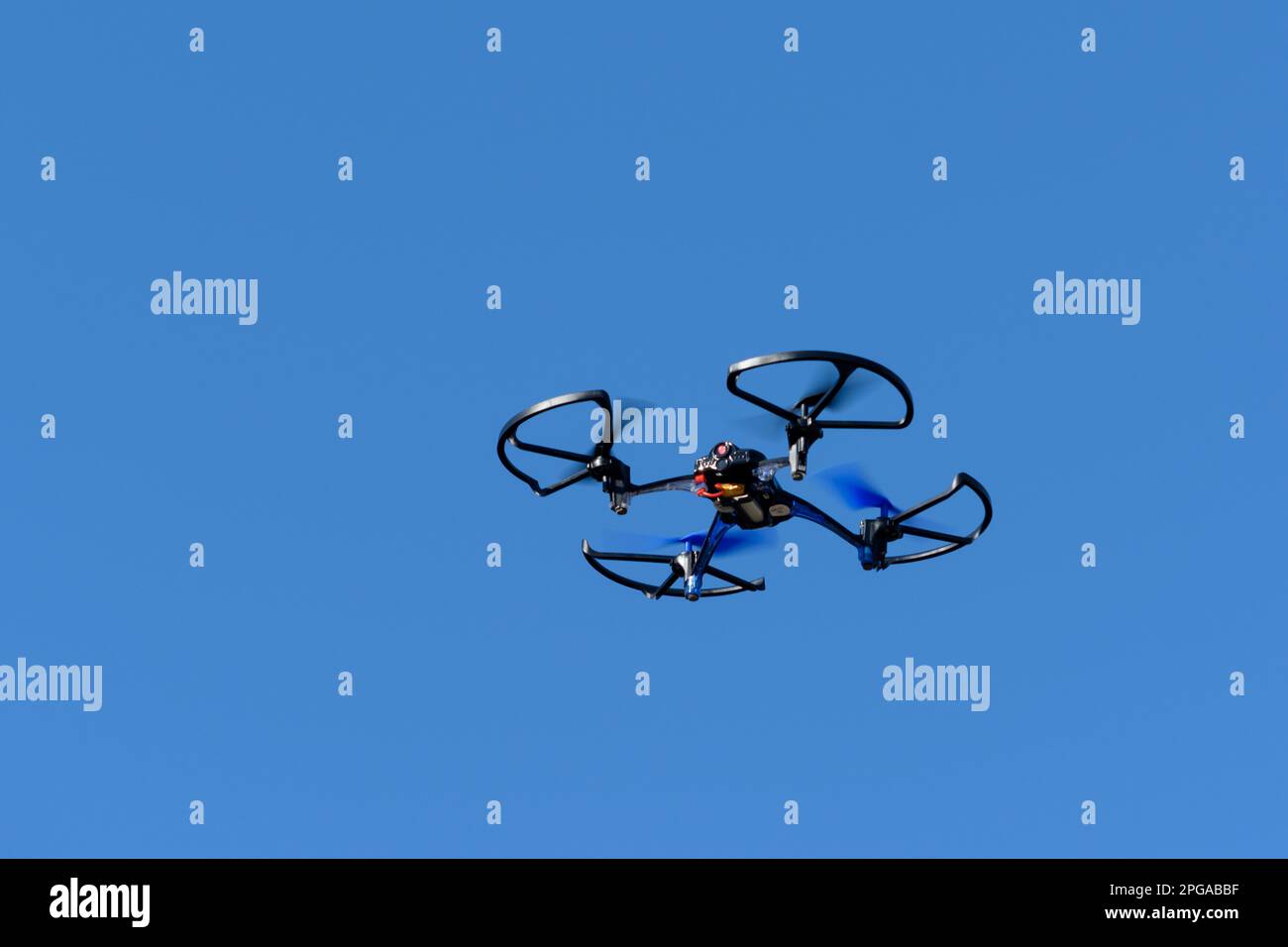 remote aerial quadcopter drone, with hight resolution camera, flying in the blue sky, which makes a survey of the territory, Italy Stock Photo