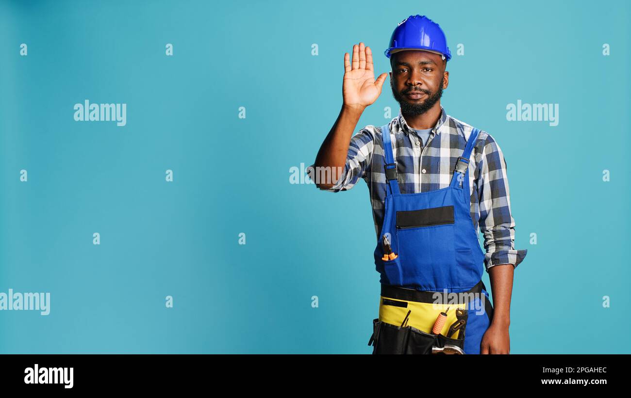 Professional builder raising hand doing stop gesture, showing refusal ...