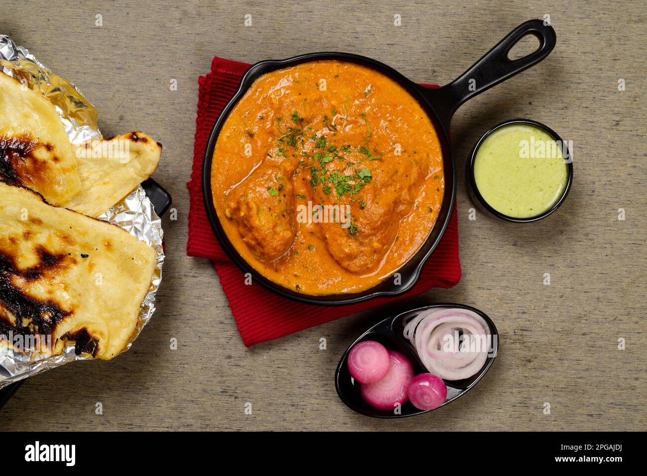 Murgh makhani or butter chicken served with naan and mint chutney Stock