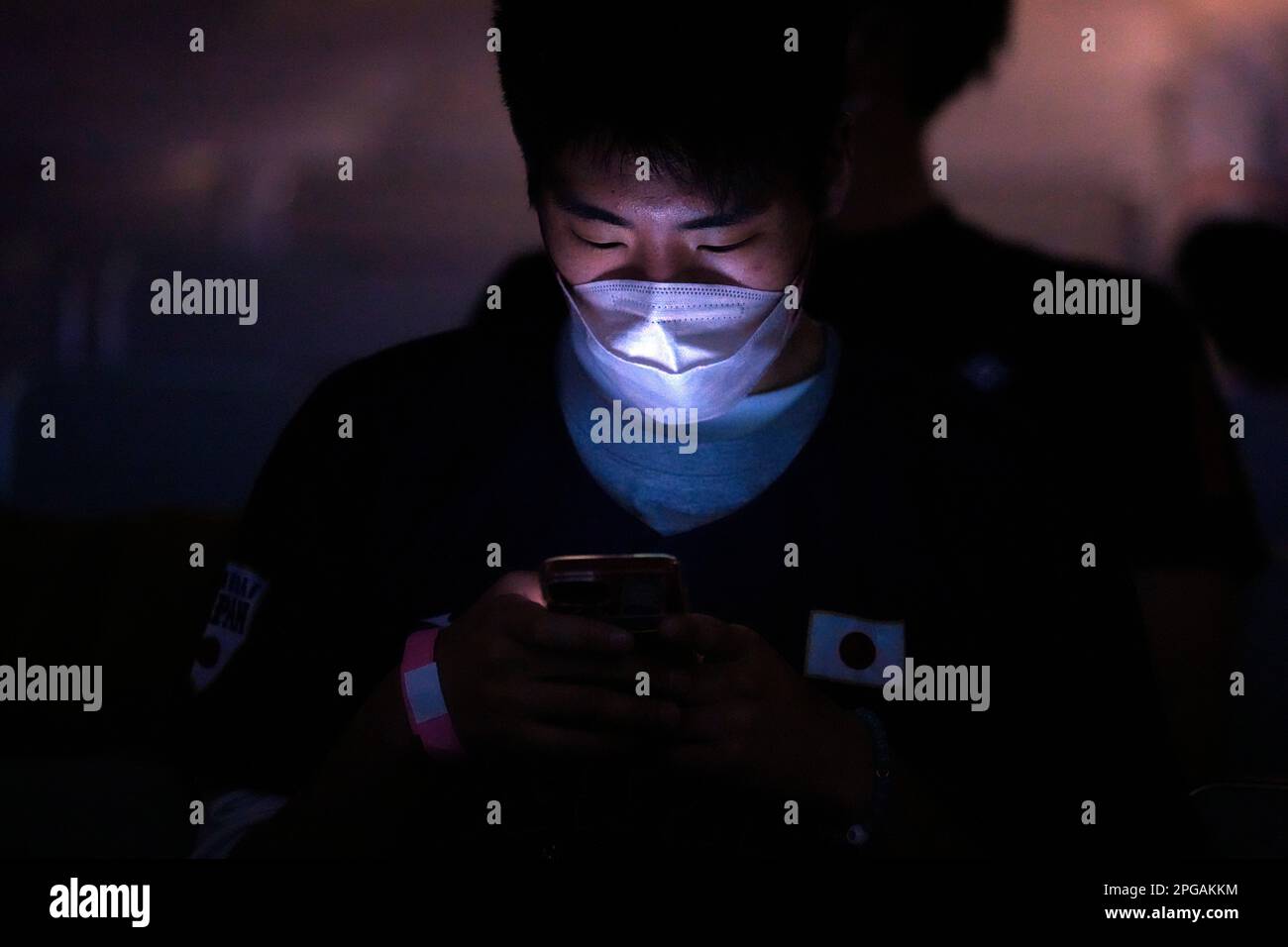 One of Japan fans uses a mobile phone before he watches on a live stream of a World Baseball Classic (WBC) final between Japan and United States being played at LoanDepot Park