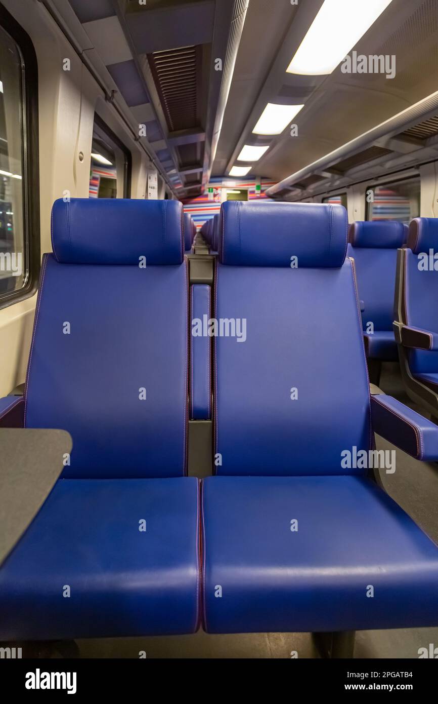 Seats in a suburban train. Passenger Empty wagon with Blue Seats. Inside High Speed Train. Empty train with seats and Interior of train with outside view from inside. Empty seats, Close up Stock Photo