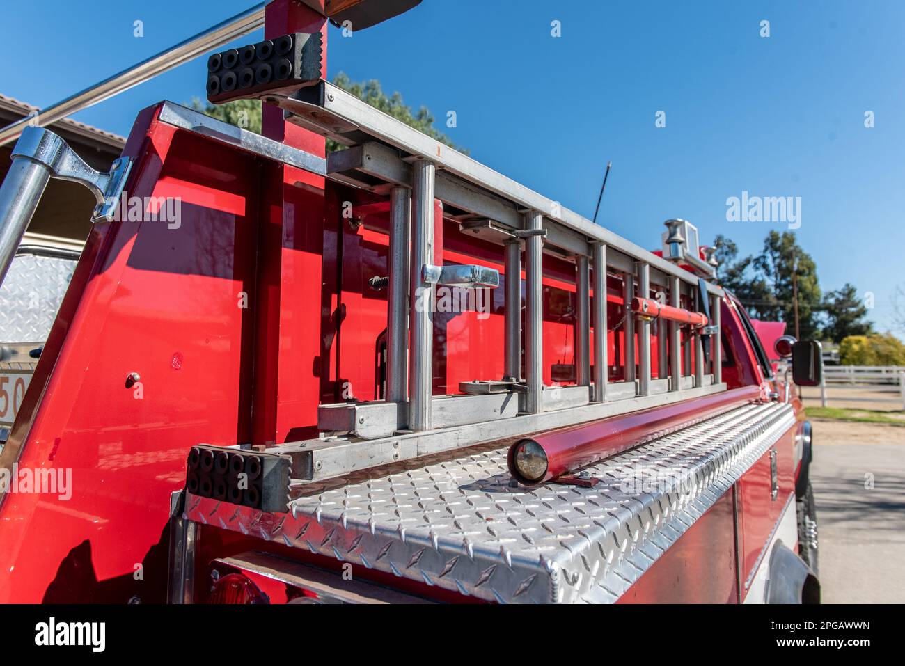 Sturdy extension ladder is firmly secured to the side of the red fire